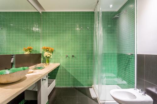 a green tiled bathroom with a sink and a shower at Hotel BA Jardines Palermo in Buenos Aires