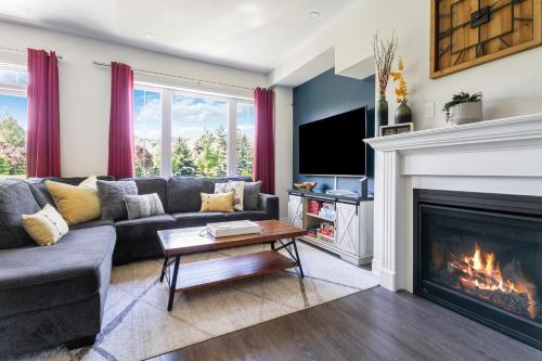 a living room with a couch and a fireplace at Modern home with a pool sauna pooltable & mountain view in Collingwood