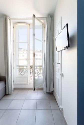 ein leeres Zimmer mit einer Tür und einem Fenster in der Unterkunft STUDIO ** VIEUX PORT in Marseille