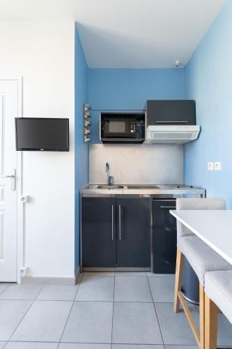 eine Küche mit einer Spüle und einer Mikrowelle in der Unterkunft STUDIO ** VIEUX PORT in Marseille