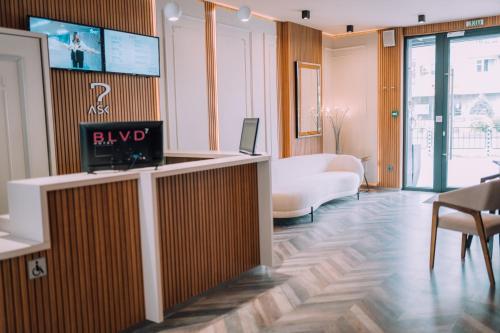 a lobby with a reception desk with a tv on the wall at Hotel BLVD 7 in Plovdiv