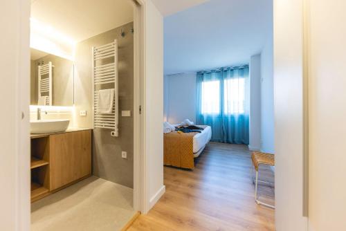 a bathroom with a sink and a bed in a room at Bravissimo Domènica, 2 bedrooms and balcony in Girona