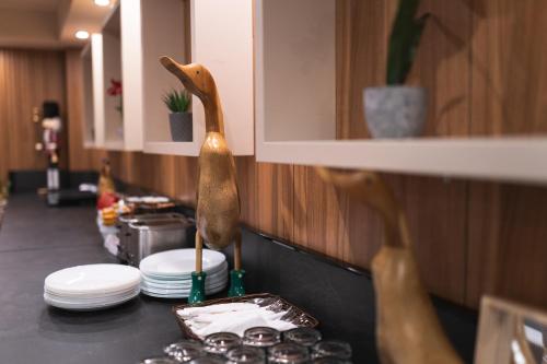 a kitchen counter with plates and a wooden bird on it at Hotel BLVD 7 in Plovdiv