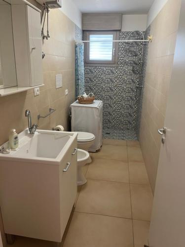 ein Bad mit einem WC, einem Waschbecken und einer Dusche in der Unterkunft Appartamenti Torre Lapillo in Torre Lapillo