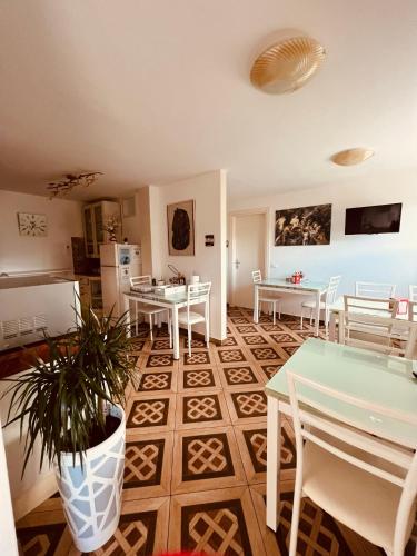 a living room with tables and chairs and a kitchen at Affitta camere La Fenice di Folli Lorella in Puegnano del Garda