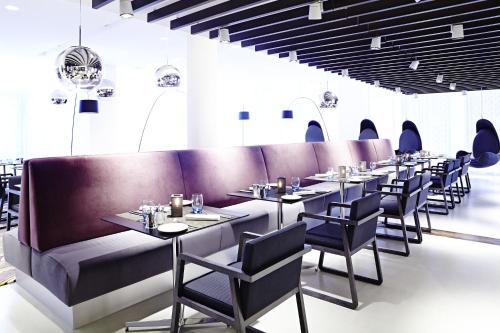 a row of tables and chairs in a restaurant at Novotel London Brentford in Brentford