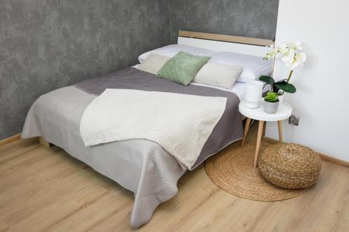 a bedroom with a bed and a nightstand with a table at Apartamenty Legionów 30 in Oświęcim