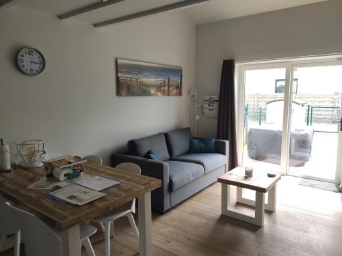 a living room with a couch and a table at SeaLodge4you in Bredene
