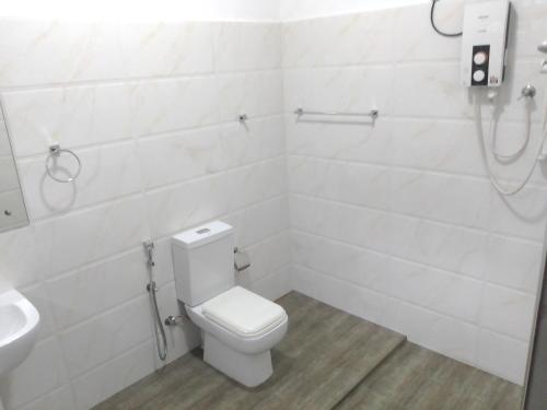 a white bathroom with a toilet and a sink at The Inn At Matale in Matale