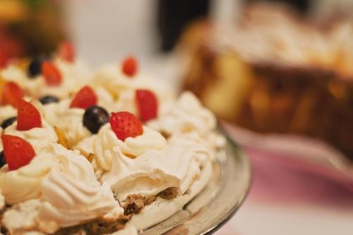a dessert with whipped cream and berries on a glass plate at Hotel Pod Lwem in Elblag