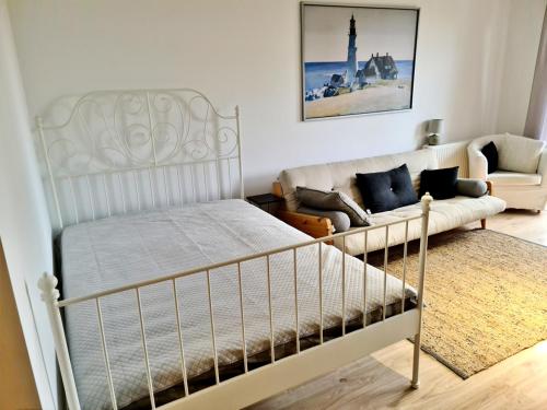 um quarto com uma cama e um sofá em Portowy - Sweet House em Świnoujście