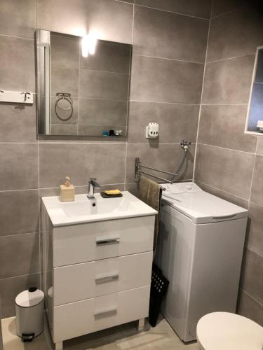 ein Badezimmer mit einem Waschbecken, einem WC und einem Spiegel in der Unterkunft Le cheval d’en fer in Bégard