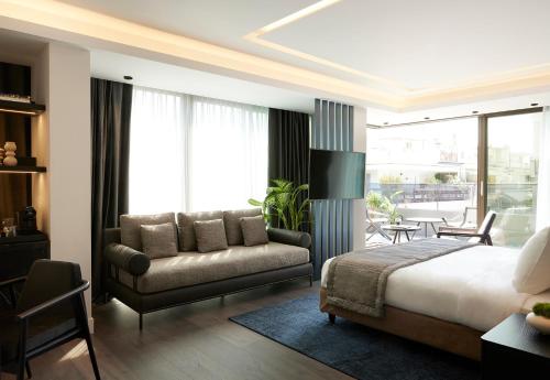 a bedroom with a bed and a couch and a chair at Teight Hotel in Thessaloniki