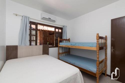 a bedroom with two bunk beds and a window at Casa térrea com 03 dormitórios perfeita para seus dias de férias na praia in Bombinhas