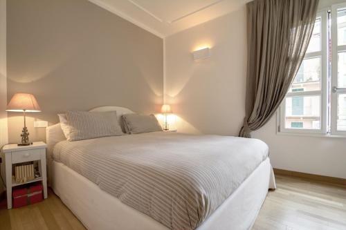 een witte slaapkamer met een groot bed en een raam bij Alassio bnb Apartments in Alassio