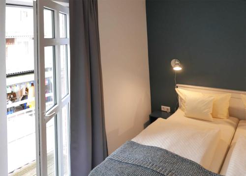 a bedroom with a bed next to a window at Strandburg Juist - Turmwohnung 105 (Ref. 50957) in Juist