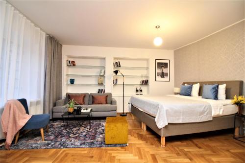 um quarto com uma cama e um sofá em Tallinn City Apartments Kohtu Residence em Talin