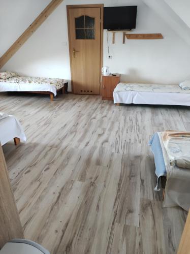 a room with two beds and a flat screen tv at U SKUPNIÓW Gliczarów Górny in Biały Dunajec