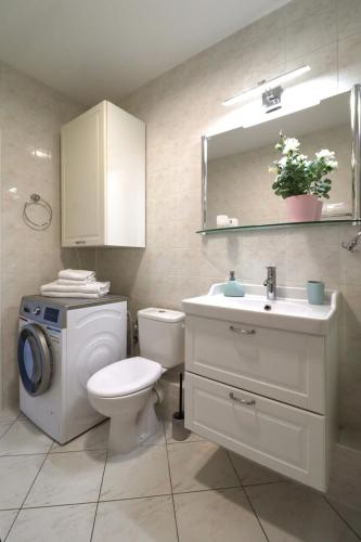 a bathroom with a toilet and a sink and a washing machine at Apartbaltic - Monte Cassino in Świnoujście