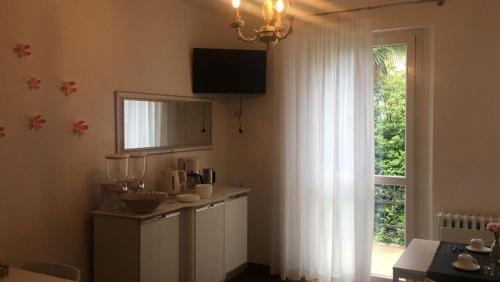 a kitchen with a window with white curtains and a counter at La Pallanzotta in Verbania