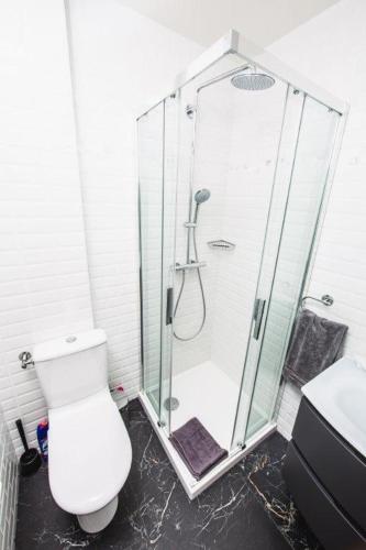 une salle de bain blanche avec douche et toilettes dans l'établissement Paris City Flat 71 M carre Appt 101 F3 Grd Paris, à Alfortville
