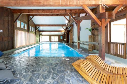 une grande piscine avec deux chaises dans un bâtiment dans l'établissement Fontaine du Mont Blanc Hotel & Spa, aux Houches