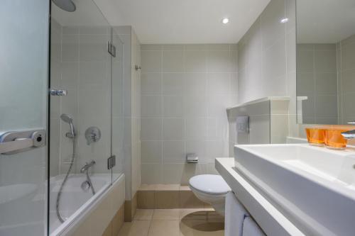 a bathroom with a toilet and a shower and a sink at Lagoona by Isrotel Collection in Eilat