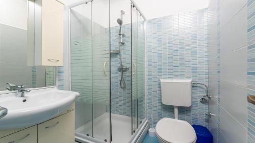 a bathroom with a shower and a toilet and a sink at Apartments in City Centar of Lovely Vrsar in Vrsar