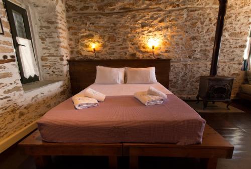 1 dormitorio con 1 cama con 2 almohadas en To Petrino, en Agios Ioannis