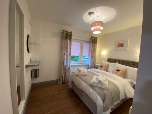 Location Location - Gorgeous 3 Bed Apartment in Killarney في كيلارني: غرفة نوم بسرير كبير ونافذة