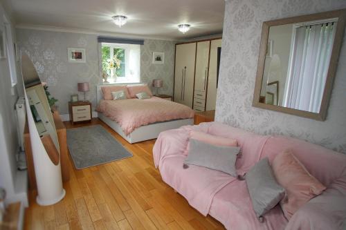 1 dormitorio con sofá, cama y espejo en Charlton House en Ventnor