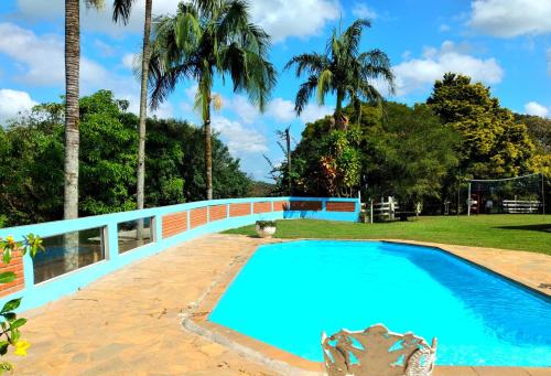 a swimming pool in a resort with a bridge at Chácara Felicidade in Socorro