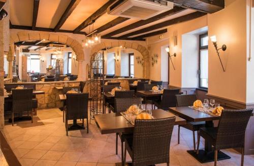 a restaurant with tables and chairs and a bar at Logis Hôtel Restaurant Cazes Arazat in Laissac