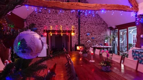 ein Zimmer mit Weihnachtslichtern und einer Backsteinwand in der Unterkunft Domaine de la Besnerie Gites avec SPA Privatif à 10 min du Mont St Michel in Tanis