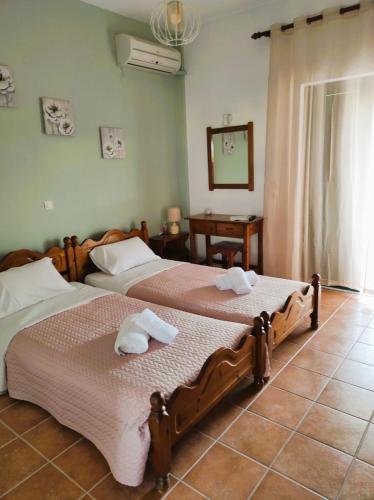 two beds in a bedroom with towels on them at Aris Seaside Issos Beach in Agios Georgios