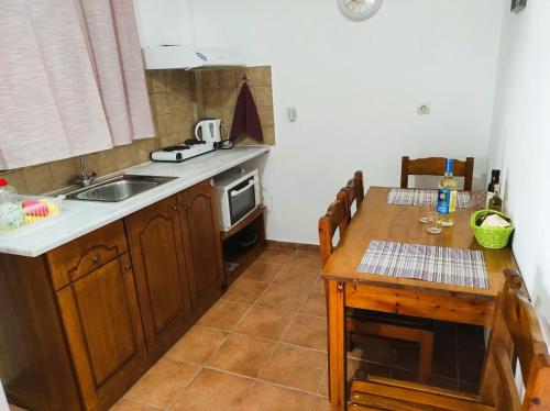 eine Küche mit einem Tisch, einem Waschbecken, einem Tisch und einem Tisch in der Unterkunft Aris Seaside Issos Beach in Agios Georgios