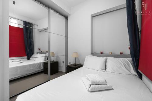 a bedroom with a white bed and a mirror at Awesome Sea View, Nilie Hospitality MGMT in Thessaloniki