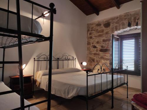 a bedroom with two bunk beds and a stone wall at Agriturismo Gragonti, Arbus Costa Verde in Arbus