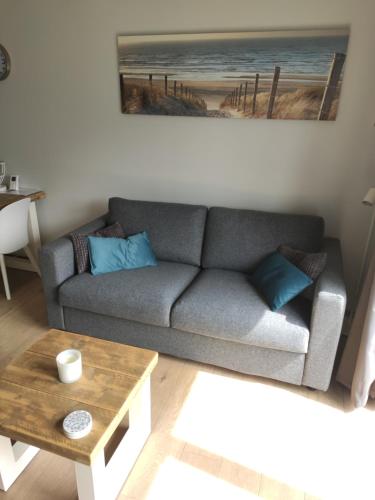 a living room with a couch and a coffee table at SeaLodge4you in Bredene