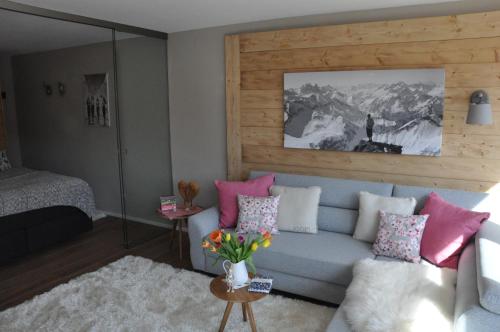 ein Wohnzimmer mit einem blauen Sofa und rosa Kissen in der Unterkunft ALMI - Alpenglück Traumhafte Whg.m.20qm Dachterr. in Oberstaufen