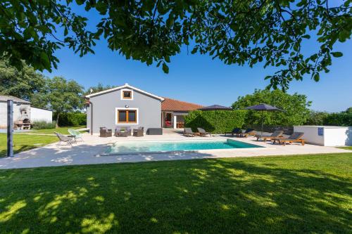 a backyard with a swimming pool and a house at Villa Anavi in Bičići