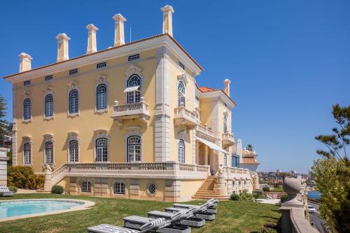 duży budynek z basenem przed nim w obiekcie Estoril Vintage Hotel w mieście Estoril