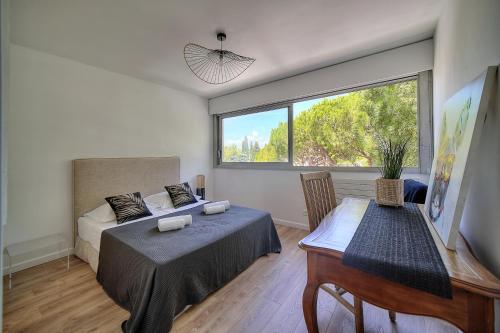 une chambre avec un lit et une grande fenêtre dans l'établissement Attique Antibois - Piscine - Vue Mer - Parking - Wifi, à Antibes