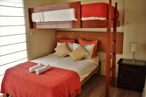 a bedroom with two bunk beds and a red bed at Kangaroo Wasi Airport Bed & Breakfast in Lima