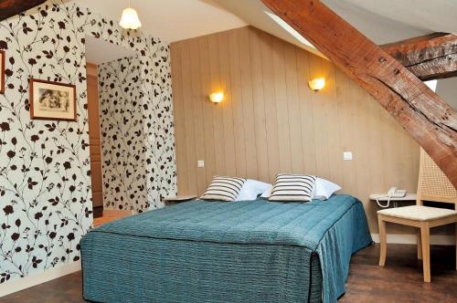 - une chambre avec un lit et une couette bleue dans l'établissement Hotel restaurant L'Amphitryon, à Coudray