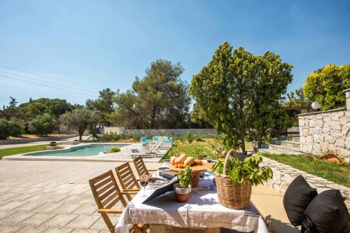 a patio with a table and chairs next to a pool at Emarmene Home with private pool near Rhodes Town & airport in Koskinou