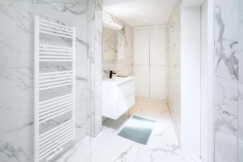 Un baño blanco con bañera y lavabo. en Beautiful Central Cityflats, en Amberes