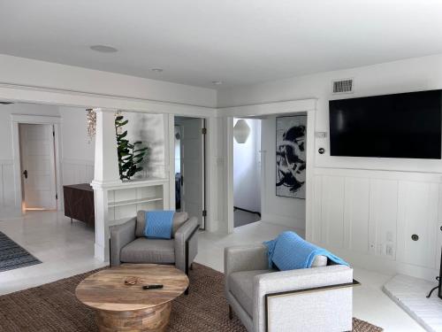 a living room with two chairs and a flat screen tv at The Craftsman House in Venice Beach in Los Angeles