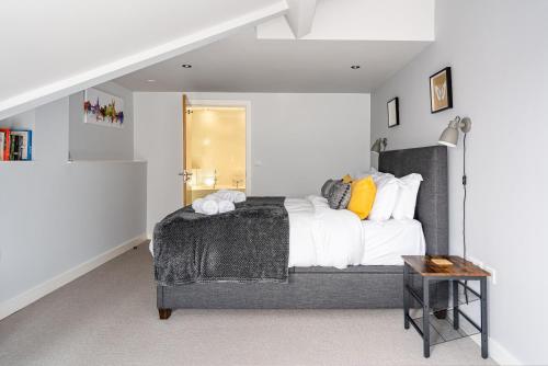 een slaapkamer met een bed met witte lakens en gele kussens bij Kensington Heights in Bath