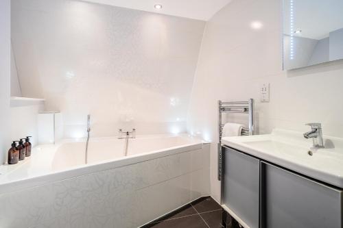 a white bathroom with a tub and a sink at Kensington Heights in Bath
